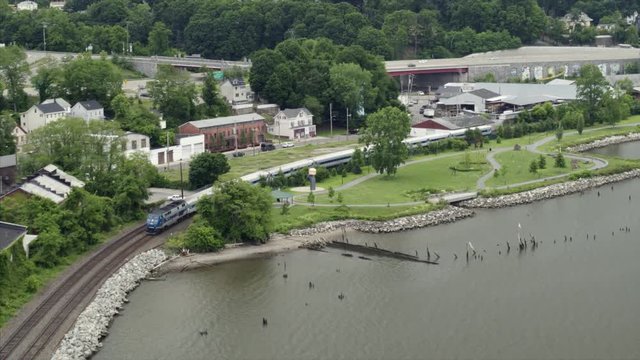 Aerial Panning Shot of Train Passing by the Hudson River in Peekskill