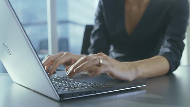 Close-up of the Businesswoman's Hands Typing on a Laptop in Her Office
