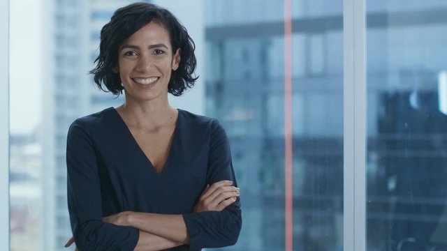 Portrait of the Successful Hispanic Businesswoman Crossing Her Arms and Smiling. Beautiful Female Executive Standing in Her Office.