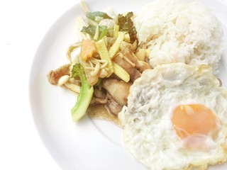 Stir fry chicken, sweet peppers, corn, broccoli, sweet basil and green beans with rice and fried egg in ธhai style in white dish on white background. Thai style food.