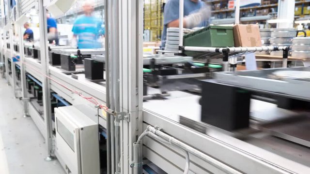 4K Time-lapse group of workers manually assemble parts and components on a industrial assembly line