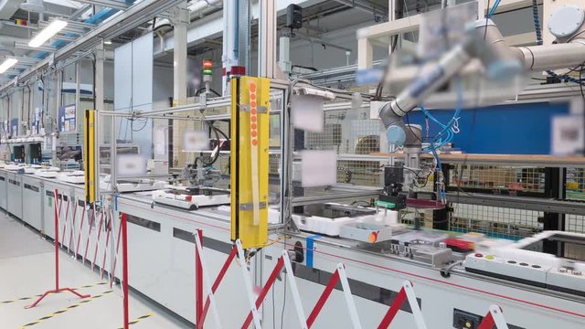 4K time-lapse of a modern industrial line production, robots and humans work at the same place
