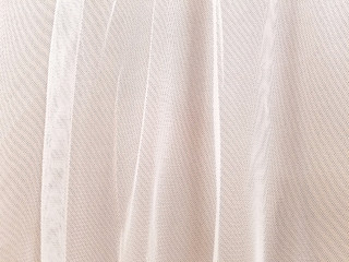 close up of blush colored sheer tulle fabric