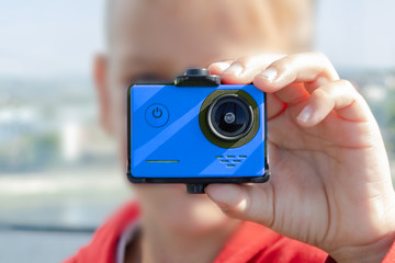 action camera red in the hands of a man, blurred background