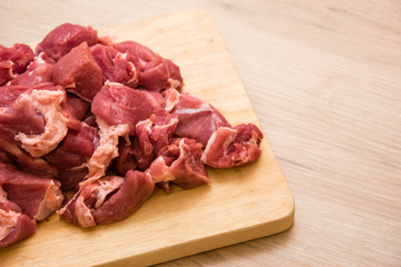 Pieces of sliced raw meat on a wooden board.