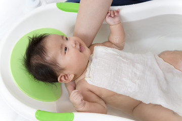 Fototapeta na wymiar 新生児の入浴・沐浴方法を説明するマニュアル用写真、沐浴布で胸を覆い保温安心させる方法