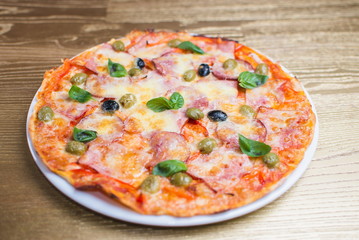 pizza with basil on a white plate