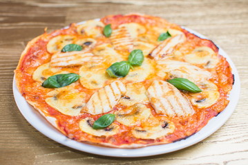 pizza with basil on a white plate