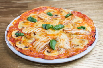 pizza with basil on a white plate