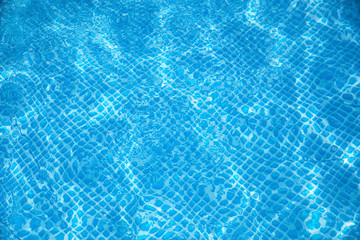 Blue and bright ripple water and surface in swimming pool , Beautiful motion gentle wave in pool