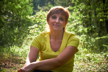 Nice senior woman resting after exercising in the park. Active mature lifestyle. Lifestyle concept