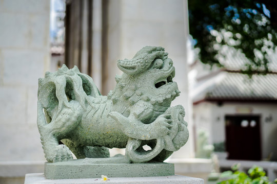 Chinese style Stone lion statue holding a ball in Wat Pho, Bangkok, Thailand