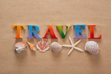 top view of travel written in colorful letters decorate with shellfish on the beach with copy space