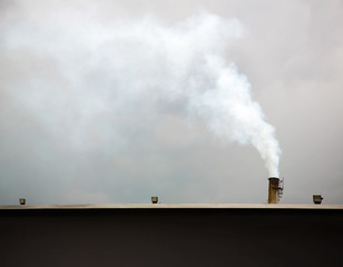 Chimney on the roof industry building  was smoke coming out. Air Pollution and Greenhouse Effect Reduction concept. Air Pollution and Reducing Processes in Industrial Processes Concept.