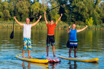 Happy friends, a SUP surfers with open arms