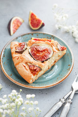 A piece of homemade sweet baked pie with figs on a blue ceramic plate. Vertical composition.