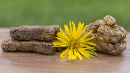 The bee propolis on the table is shaped into cubes. Bee Propolis is formed into cubes on a green background