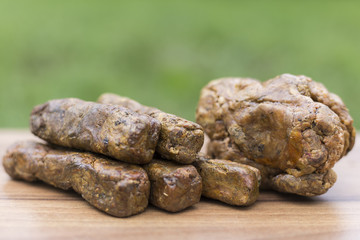 The bee propolis on the table is shaped into cubes. Bee Propolis is formed into cubes on a green...