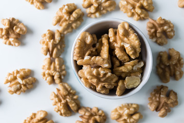 Nuts, walnuts, tasty and healthy food with lots of vitamins. Walnut in bowl on white wooden table. Top view