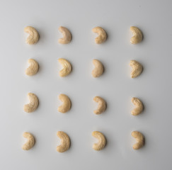 Fototapeta na wymiar Nuts, cashew placed in pattern on a white wooden table. Tasty and healthy food with lots of vitamins. Top view