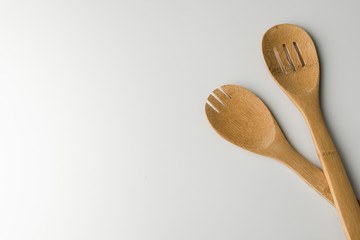 Two wooden spoons on a white background. Top view with copy space for text