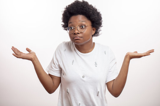 good looking african woman with arms out shrugs shoulders as she doesn't know what to do in the situation i don't know.carefree woman with raised arms