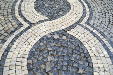 Stone pavement texture in perspective. White and black stones make pattern