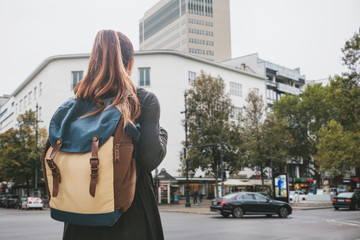 A student or a teenager or a tourist girl with a backpack on the street in Berlin in Germany.