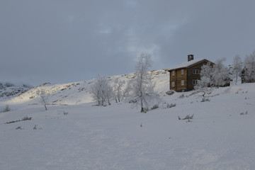 Winter log cabins in snow landscape in Norway
