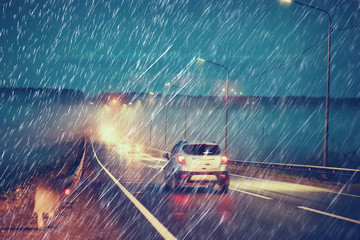 blurred background autumn auto rain on the road / night lights and raindrops in the autumn traffic jam on the road, urban style traffic - obrazy, fototapety, plakaty