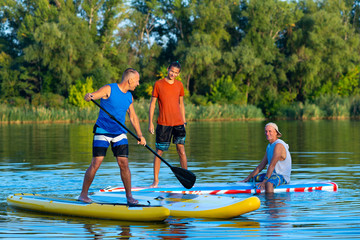 Happy friends, a SUP surfers communicate and having fun