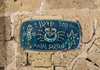 A sign with the name of the street in Hebrew - Lane of the sign of the zodiac Cancer in on old city...