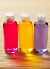 jars with gel, shampoo and soap stand on a bamboo mat