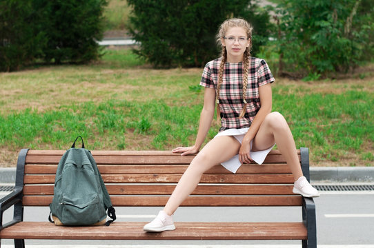 sexy nerd girl in defiant pose sitting on bench