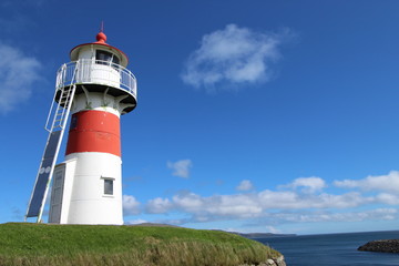 Red and white lighthouse in Torshavn, faroe islands. Sunny summer day