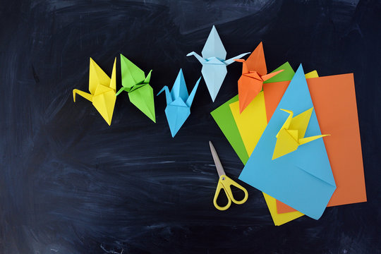  Color paper cranes of origami from paper on a black background