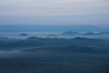 Fototapeta premium In the morning mountain range with visible silhouettes throug with fog
