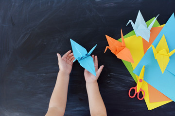  Color paper cranes of origami from paper on a black background