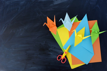  Color paper cranes of origami from paper on a black background