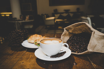 Breakfast with cup of coffee, fresh croissantson white wooden background, selective focus