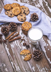 Freshly baked natural cookies for Santa with cup of milk on a wooden table.