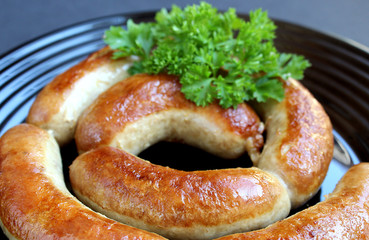 fried homemade sausage in a bowl decorated with parsley