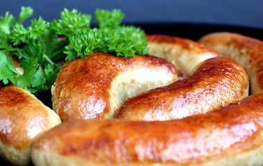 fried homemade sausage in a bowl decorated with parsley