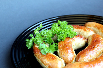 fried homemade sausage in a bowl decorated with parsley
