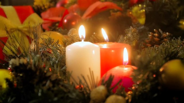 Closeup 4k video of three burning candles on Christmas eve