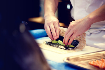 Japanese chef at work preparing delicious sushi roll © NORN