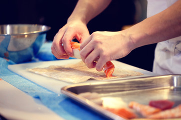 Japanese chef at work preparing delicious sushi roll