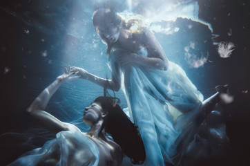 Obraz na płótnie Canvas Beautiful woman swimming with fancy dress underwater