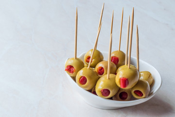 Cocktail Green Olives Stuffed with Red Paprika Pepper Served with Toothpick.