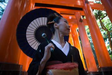 Fototapeta na wymiar Beautiful japanese senior woman walking in the fushimi inari shrine in Kyoto